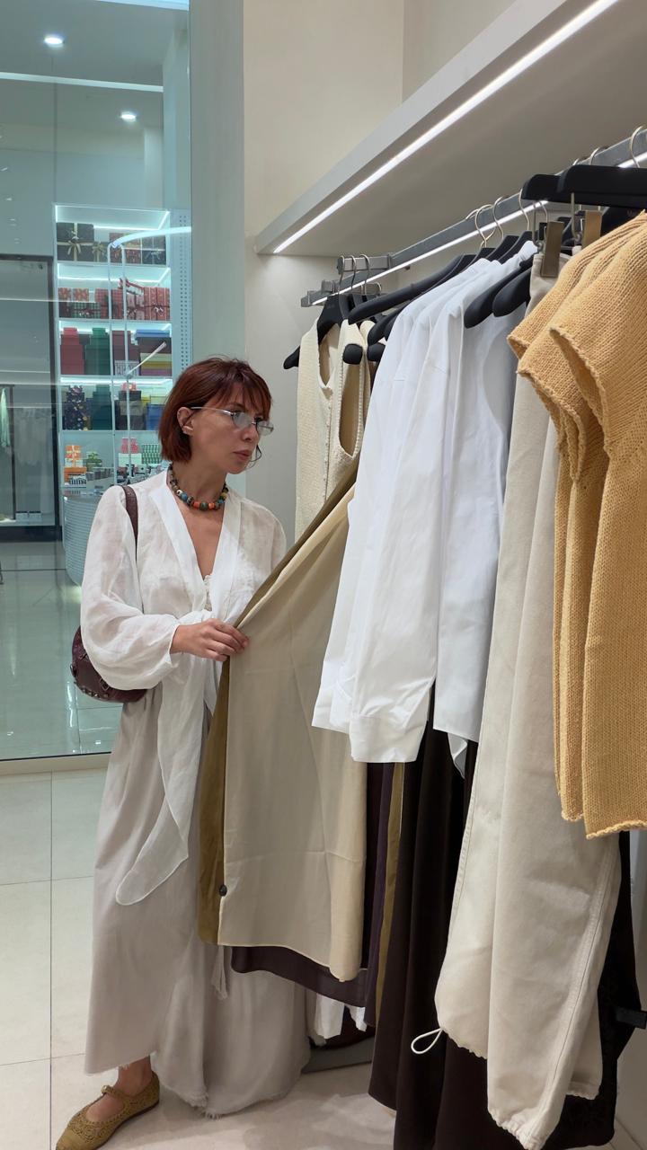 Jasmine selecting neutral pieces from a rail during a personal shopping session