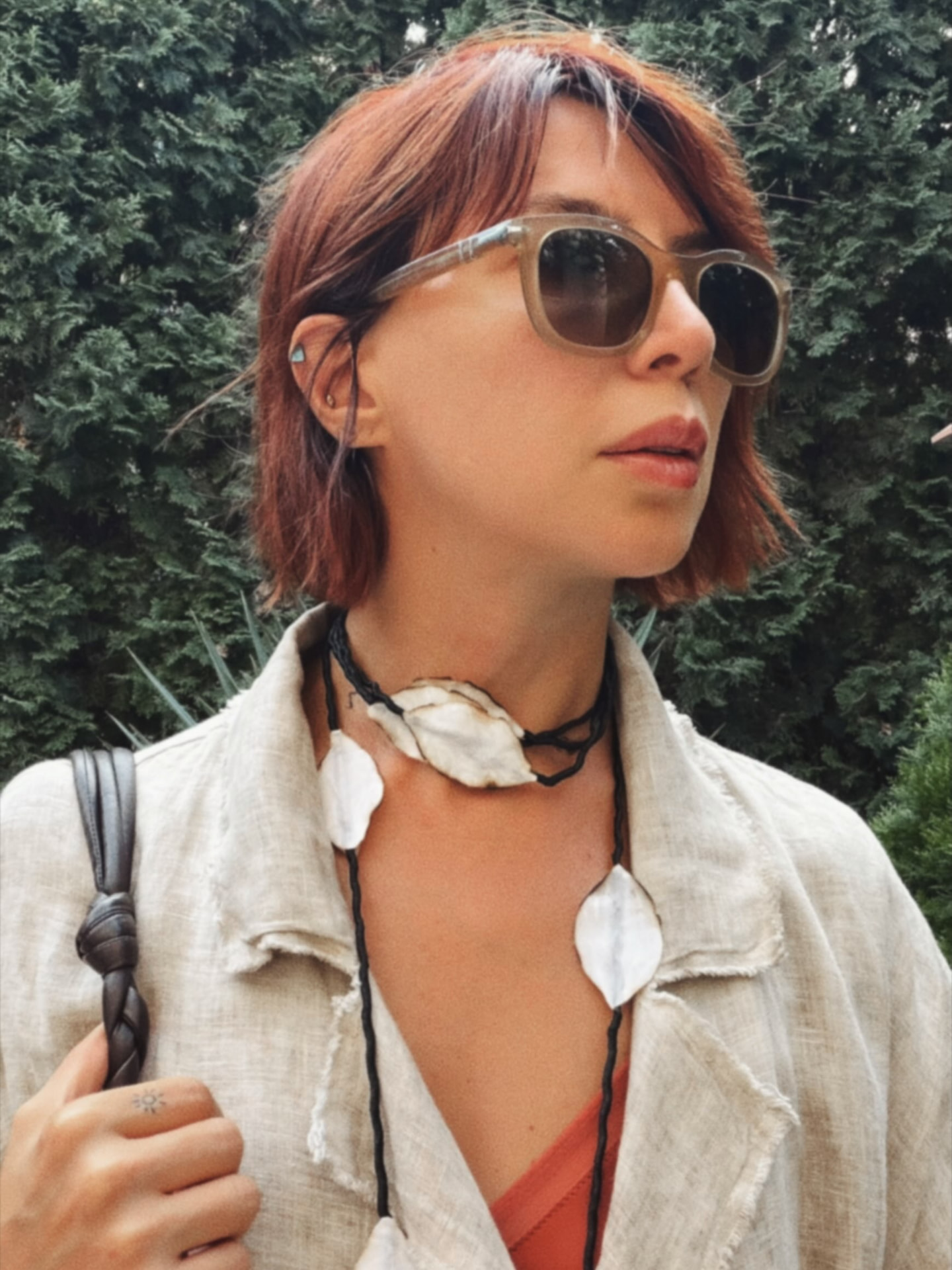 Close portrait wearing a linen jacket and a hand-made shell and cord necklace