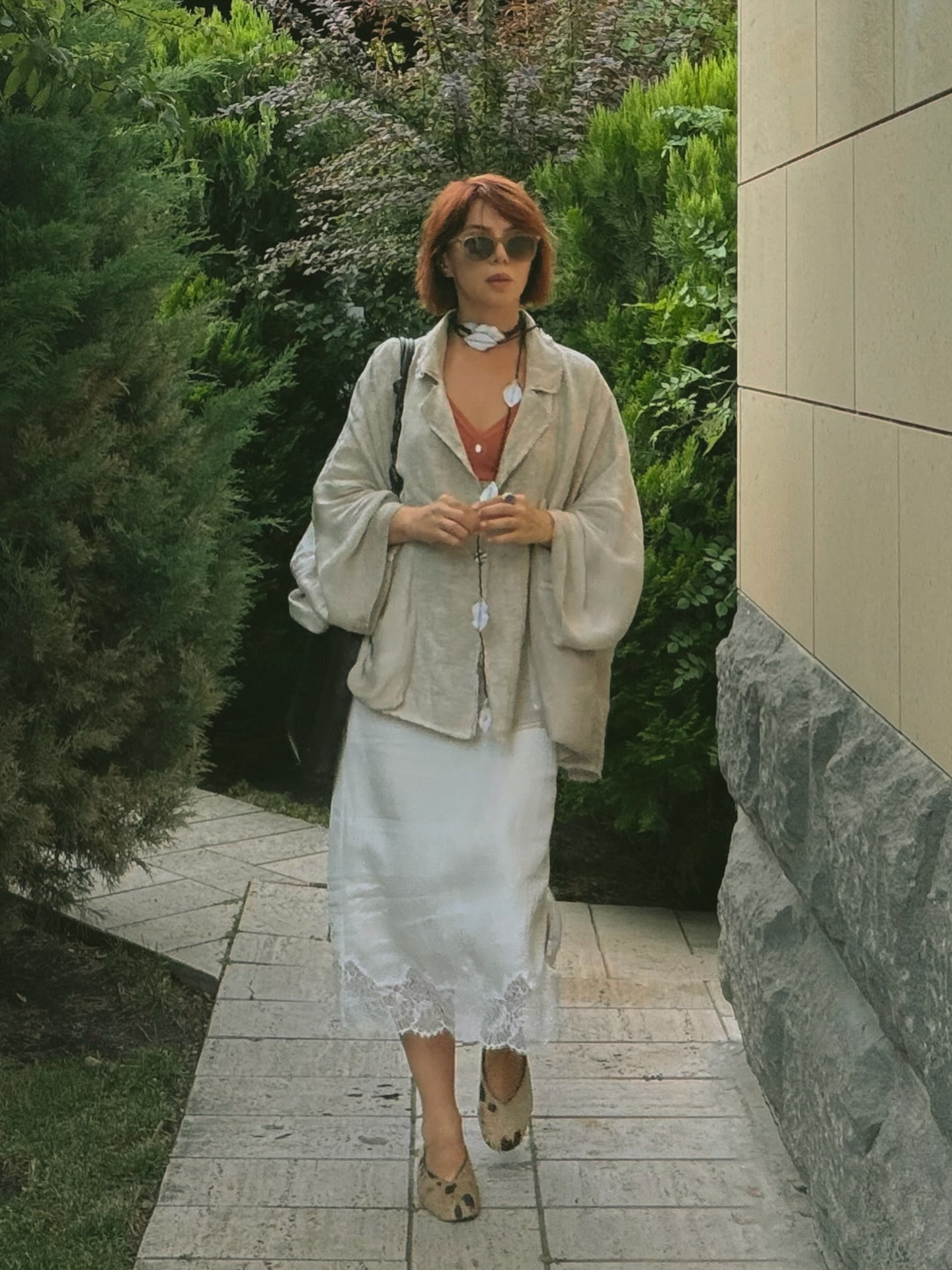 Full-length look: oversized linen jacket over a white lace-trimmed slip skirt